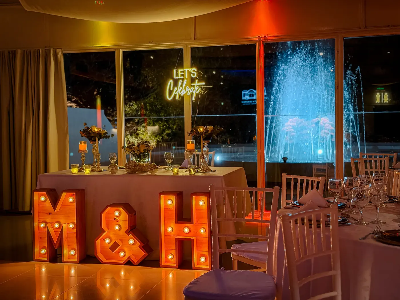 Salón de fiesta con letras luminosas y ventanales iluminados